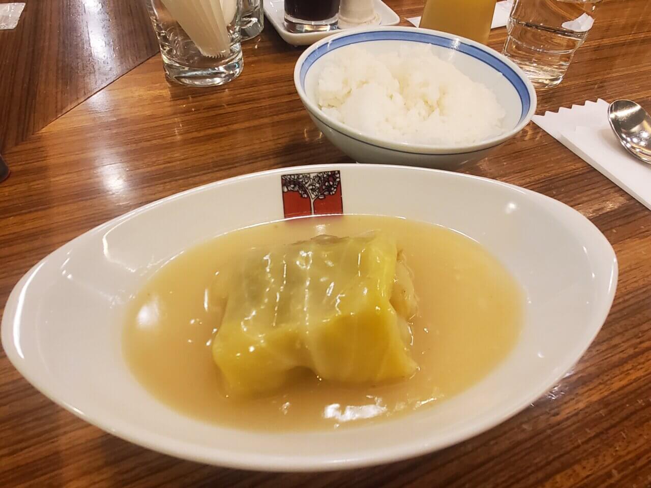 アカシア名物のロールキャベツシチュー。たっぷりのクリームソースがかかっており、ライスが添えられている。