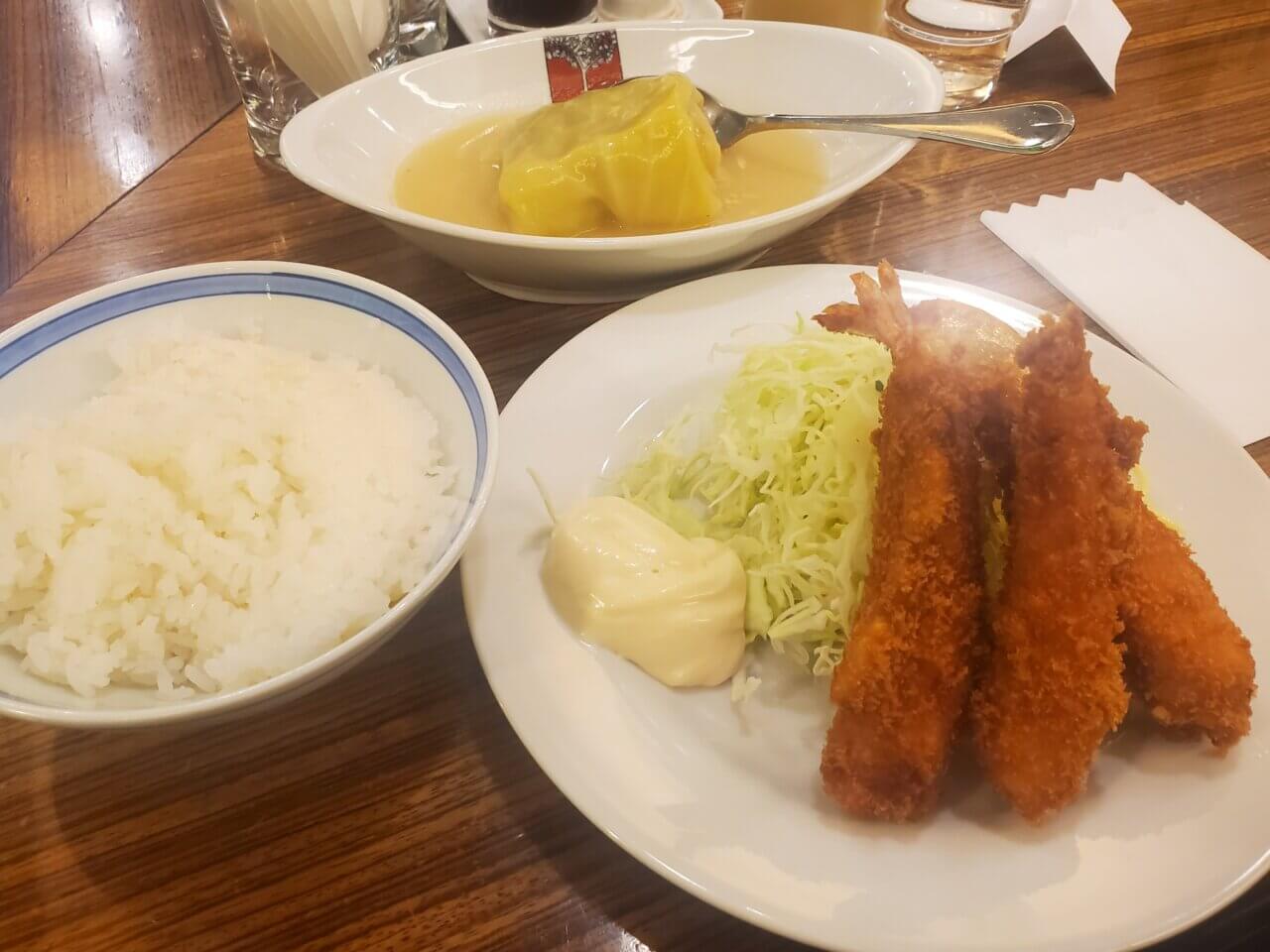 アカシアのロールキャベツとエビフライの定食。ご飯、ロールキャベツ、エビフライがセットになっている。